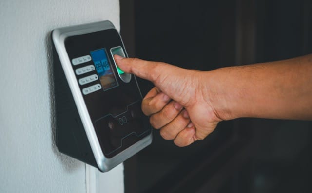 A person using a fingerprint scanner on an access control system to enter a home. This is an example of advanced Access Control Installation for coventry Homes.