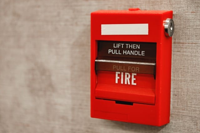 Fire alarm pull station on a wall, ensure proper maintenance to prevent false alarms from your fire alarm system.