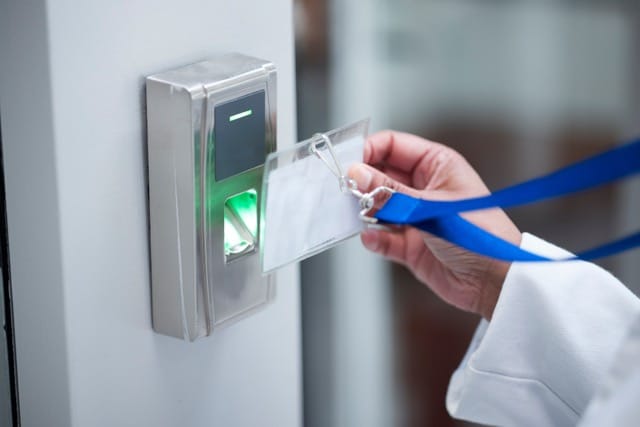 Access card being swiped at an access control scanner, illustrating why access control systems are essential for secure space management.