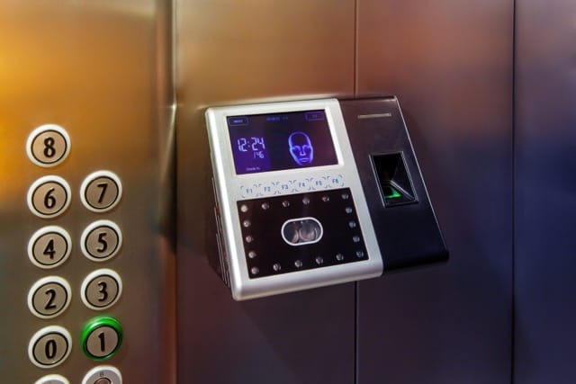 close-up of an advanced biometric scanner in an elevator, featuring fingerprint and facial recognition. Ongoing access control maintenance is crucial to keep the system secure and reliable.