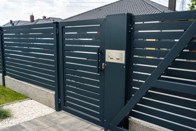 Modern electric gate with horizontal slats, an ideal choice among electric gate options for homes.