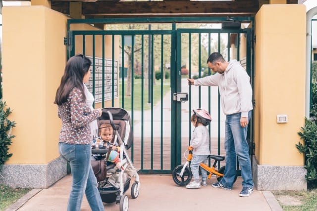 Family entering through an electric gate, showcasing the benefits of electric gate options for homes.