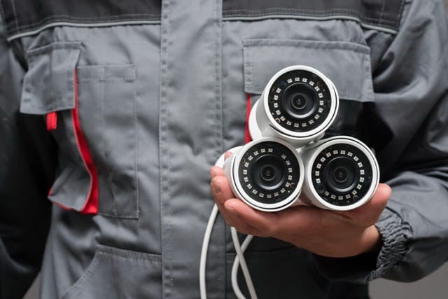 How To Choose The Best Security System Installation Provider In Coventry: a cctv installer carrying 4 fire alrams.
