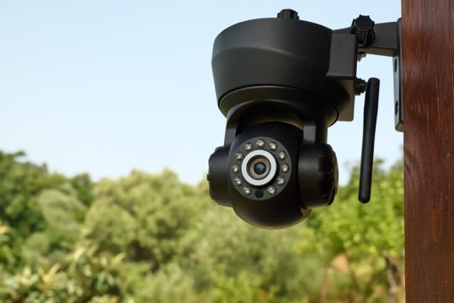 Security camera on the wall of a building with nature in background that represent cctv camera benefits